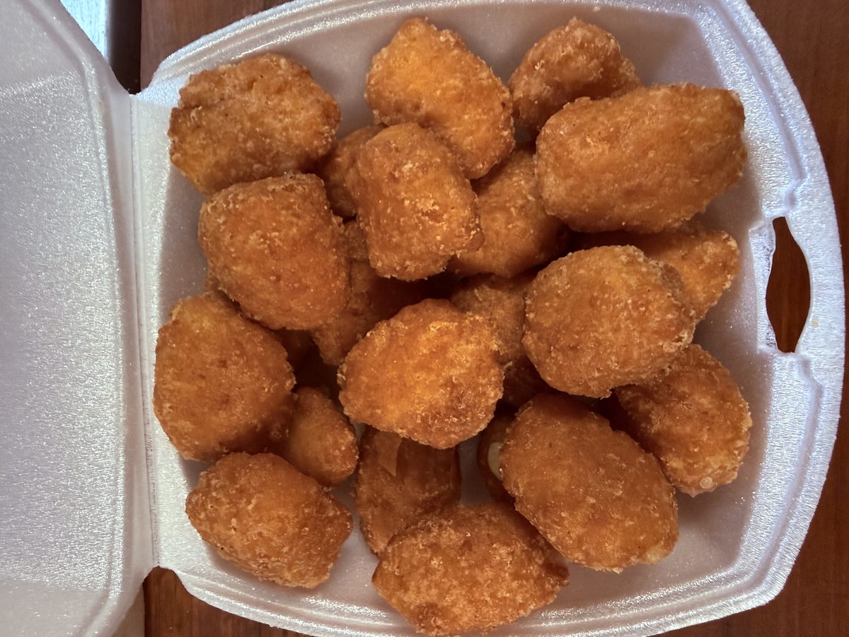 A to-go box full of golden fried appetizer bites