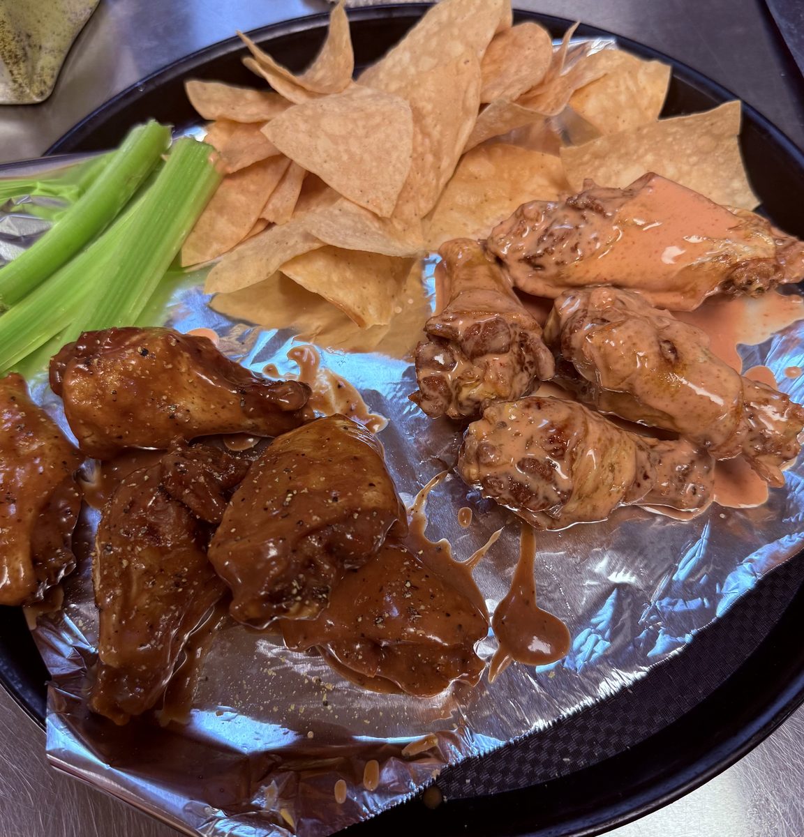 Wings in two sauces with tortilla chips and celery